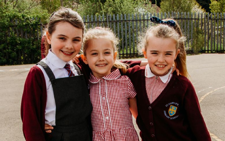 3 girls in uniform smiling 